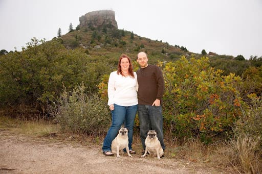 Animal Dental Care and Oral Surgery Castle Pines - a couple standing outdoors with their two pugs