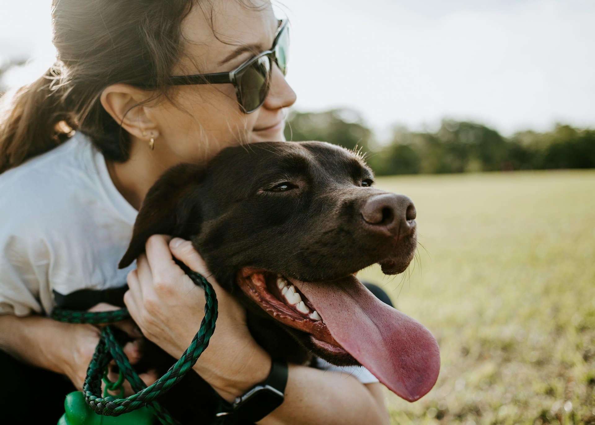 A person is hugging and loving on their dog.